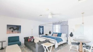 Ein modernes Schlafzimmer mit Bett, Schreibtisch, Sessel und Sofa.