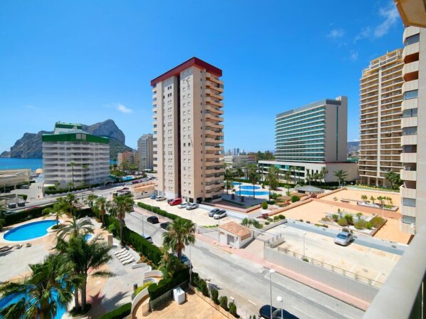 Um hotel moderno com muitos andares, piscina e vista para a costa.