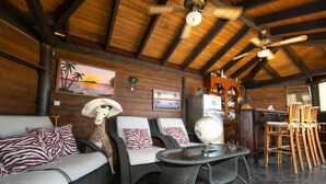 A cozy room with a high ceiling, wooden beams, wicker furniture, and a globe on a table. - Vacation home Noosa by Interhome (Calpe/Calp)