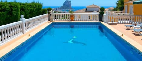 A rectangular swimming pool with a white balustrade, surrounded by a white fence.