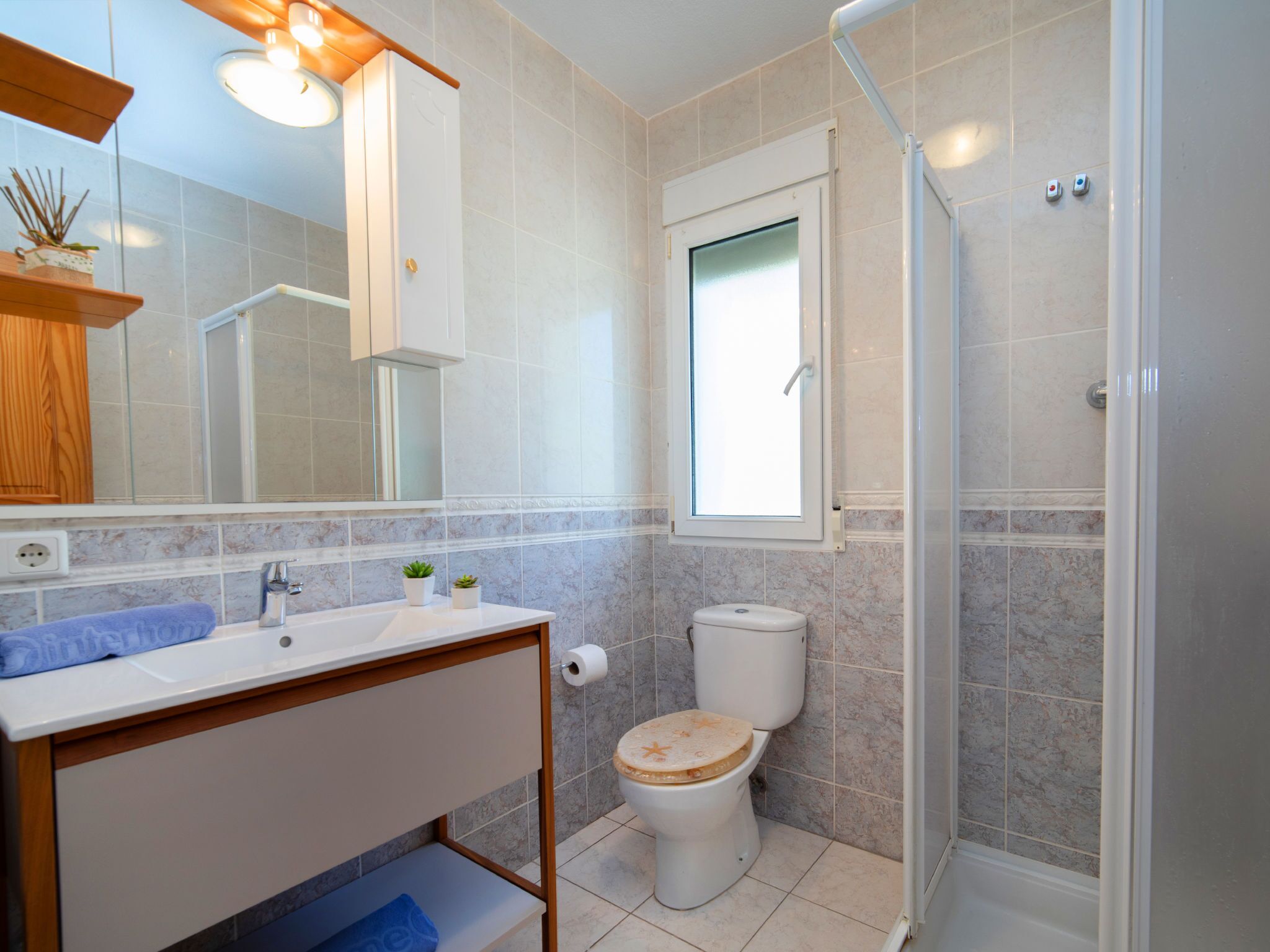 Une salle de bain équipée d’une douche, de toilettes, d’un lavabo et d’un miroir.