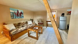 Ein Wohnzimmer mit einer Couch, einem Couchtisch und einem Gemälde von Pferden.