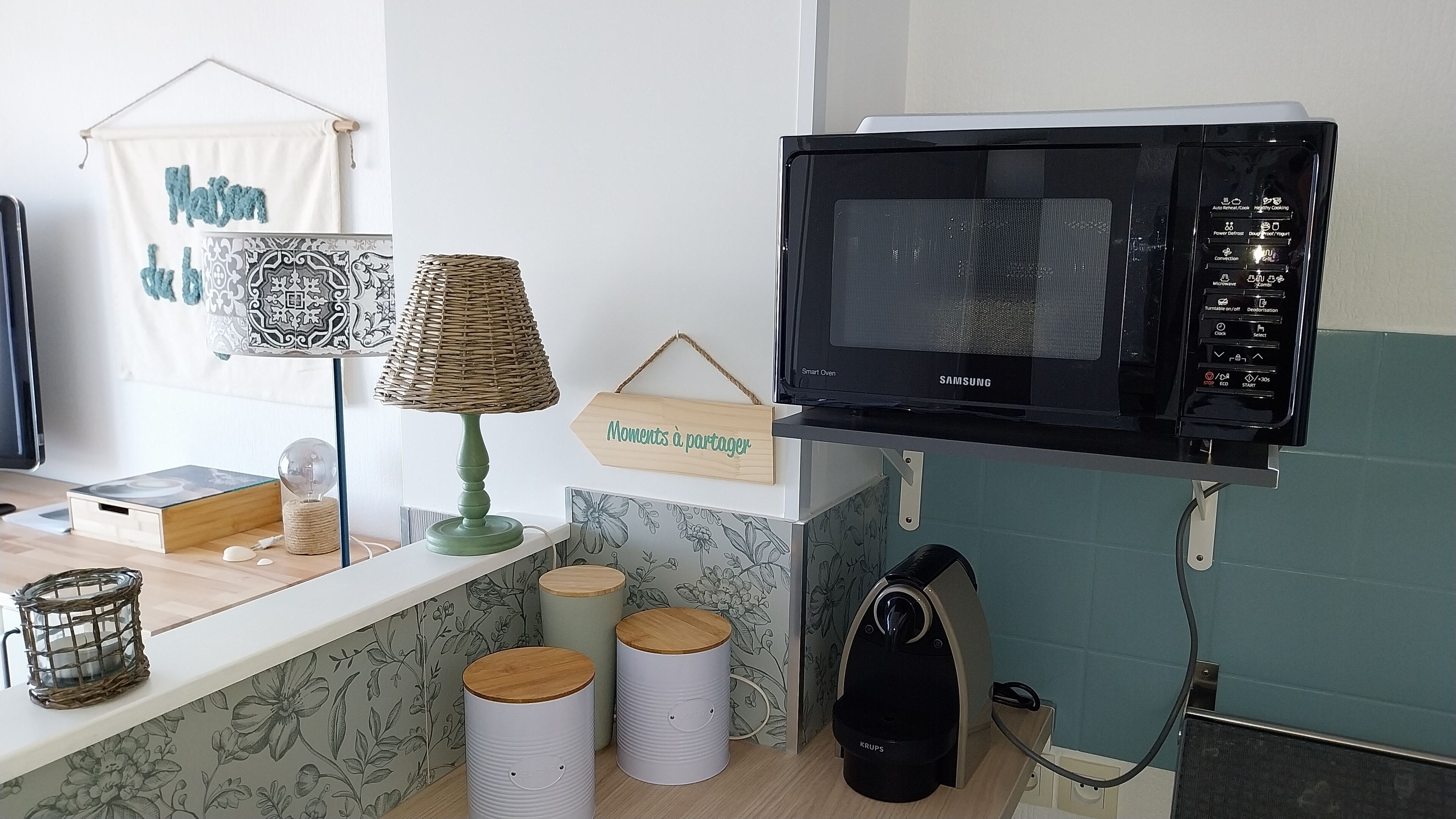 Et køkken med en Samsung smart ovn, en fletlampe og et skilt med teksten "Moments to share".