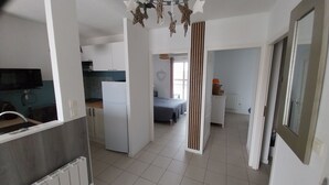 A modern apartment with a kitchen, a dining area, and a bedroom.