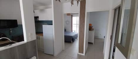 A modern apartment with a kitchen, a dining area, and a bedroom.
