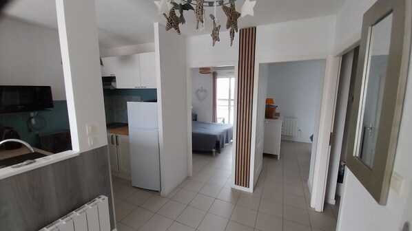 A modern apartment with a kitchen, a dining area, and a bedroom.