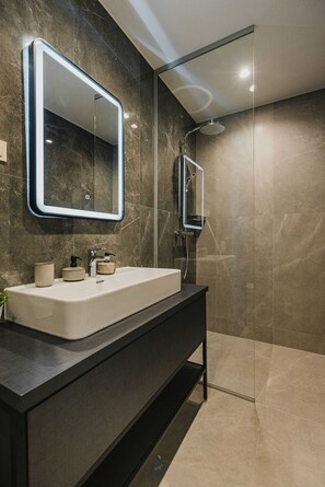 A modern bathroom with a large mirror, a sink, and a shower. - 4BD villa for up to 8 with large swimming pool, jacuzzi, sauna, gym, bocci (Brnobići)