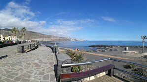 A coastal promenade with stone steps, a wooden deck, and a railing overlooking the sea. - Arenitas Beach.  An oasis by the sea (CN)