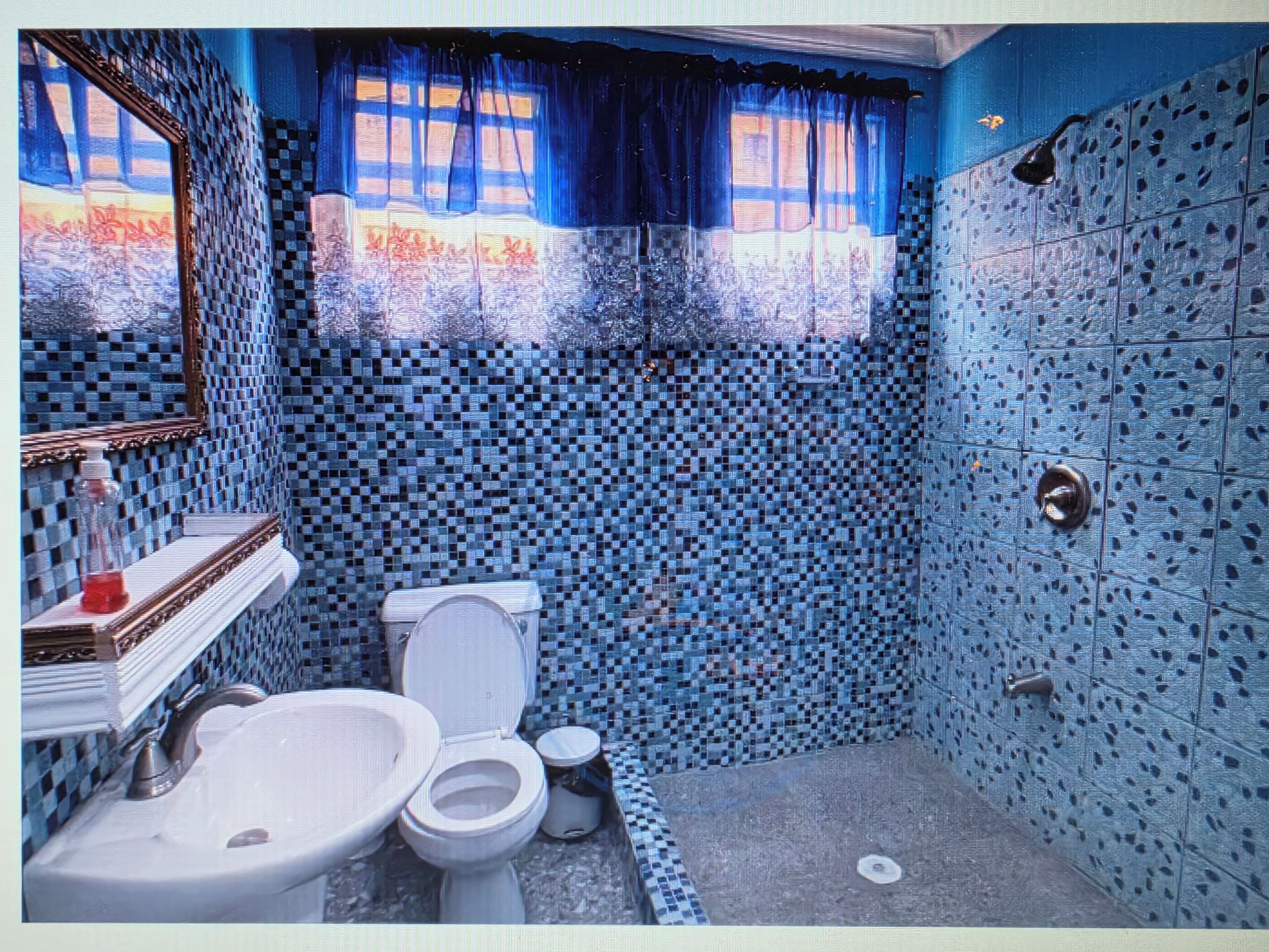 Ein Badezimmer mit gefliesten Wänden, einem Waschbecken, einer Toilette und einer Duschkabine.