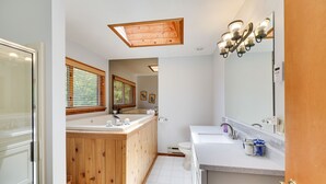 A modern bathroom with a wooden vanity, a large mirror, and a skylight. - Pocono Chalet- walking distance to Lake Wallenpaupack- 3 Full baths (Lakeville)