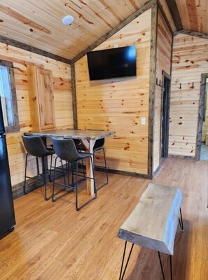 Cozy retreat with a dining area, flat-screen TV, and comfortable bench.