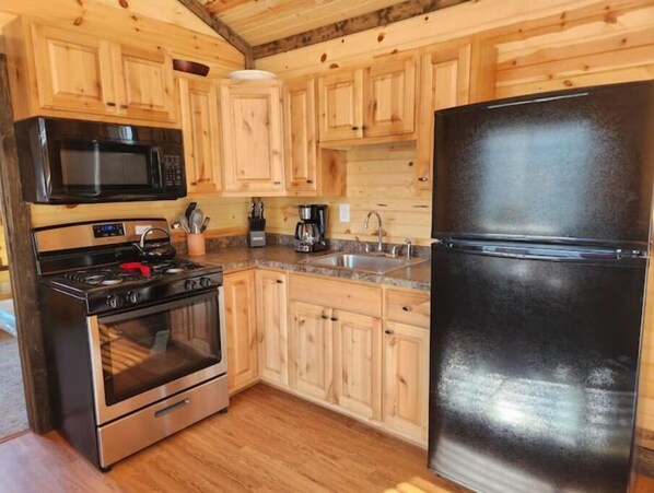Effortlessly prepare meals in this well-equipped kitchen with a stainless steel stove, microwave, and refrigerator.