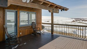 A wooden deck with two rocking chairs and a glass door leading to a room. - Cora Home w/ Mountain Views - Fishing On-Site! (Cora)