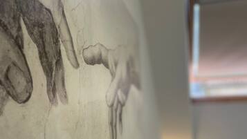 Una pared con una obra de arte texturizada que representa una figura humana.