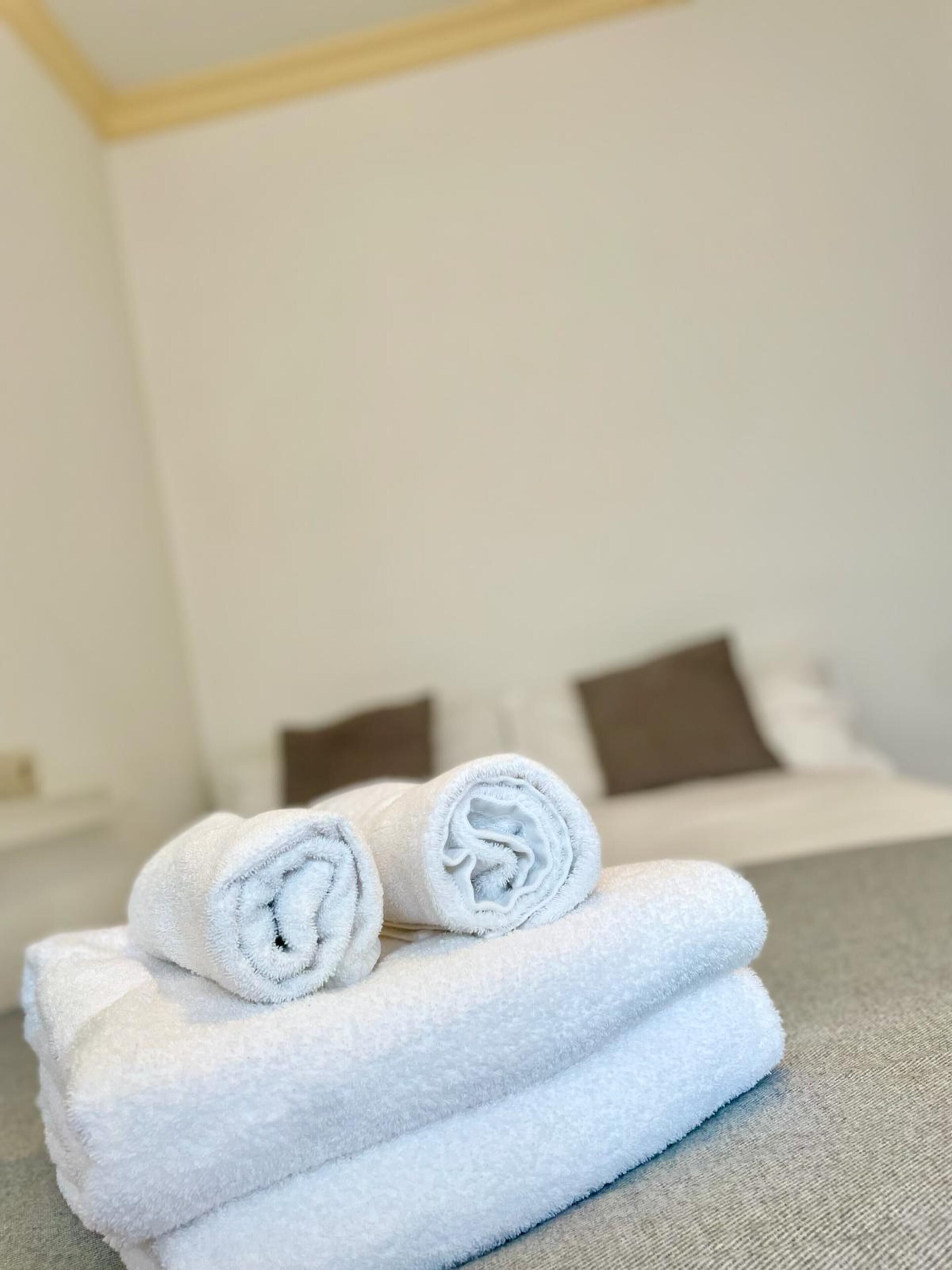 A neatly made bed with white linens and two pillows.