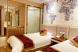 A hotel room with two beds, a wooden partition, a wall with country names, and a bedside phone. - Xingyu Theme Hotel (Huangshan Scenic Area) (Huangshan City)