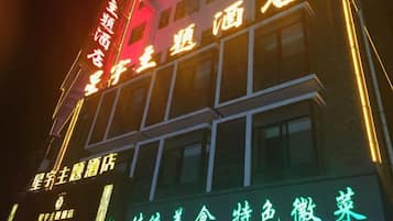 A building with illuminated signage indicating a hotel and restaurant.