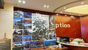 A reception area with a wooden desk, a bulletin board with photos, and a wall with the word 'ption' partially visible.
