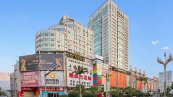 A multi-story hotel with a modern design, featuring a prominent curved facade and a tall central tower.