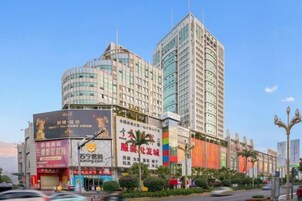 A multi-story hotel with a modern design, featuring a prominent curved facade and a tall central tower.