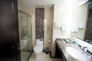 Un baño con inodoro, ducha y lavamanos.