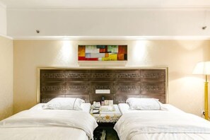 A hotel room with two beds, a headboard with a geometric pattern, a wall-mounted artwork, and a bedside table with a lamp. - Hengli Hotel (Panzhihua)