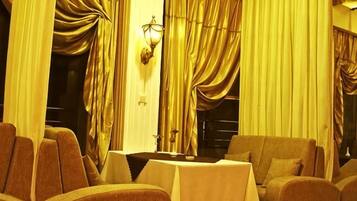 A room with a table, chairs, and curtains.