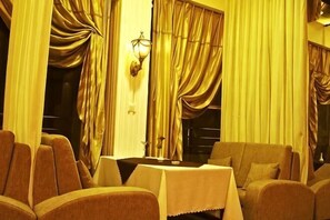 A room with a table, chairs, and curtains. - Hengli Hotel (Panzhihua)