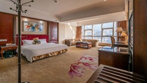 Una habitación de hotel con una cama grande, un escritorio, un sofá y una ventana con vistas.