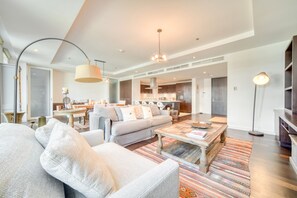 Un salon moderne comprenant un canapé, une table basse et un coin repas avec une table et des chaises.