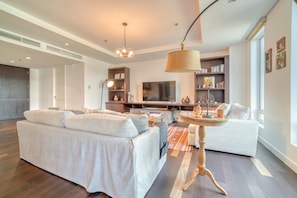 A modern living room with a sofa, a coffee table, and a television.