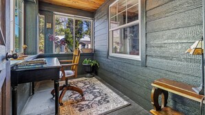 A cozy reading nook with a wooden desk, a chair, and a bench.