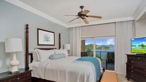 A bedroom with a bed, bedside lamps, a ceiling fan, a dresser, and a television. - Secure Booking Beachfront Ritz 3 Bedroom Property Concierge Services Included (St Thomas)