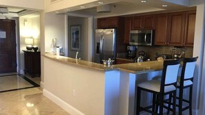 A modern kitchen with a central island, stainless steel appliances, and wooden cabinets. - Secure Booking Beachfront Ritz 3 Bedroom Property Concierge Services Included (St Thomas)