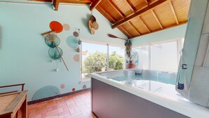 Ein Zimmer mit großem Fenster, Whirlpool und Holzboden.