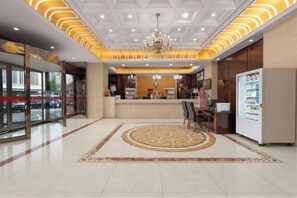 A hotel lobby with a reception desk, a chandelier, and a large window. - Haotai Hotel (Ruian Jianye) (Lu'an)