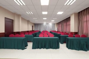 A conference room with rows of tables and chairs, a door on the left, and curtains on the right. - Haotai Hotel (Ruian Jianye) (Lu'an)