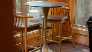 A wooden interior with a round table and two chairs.
