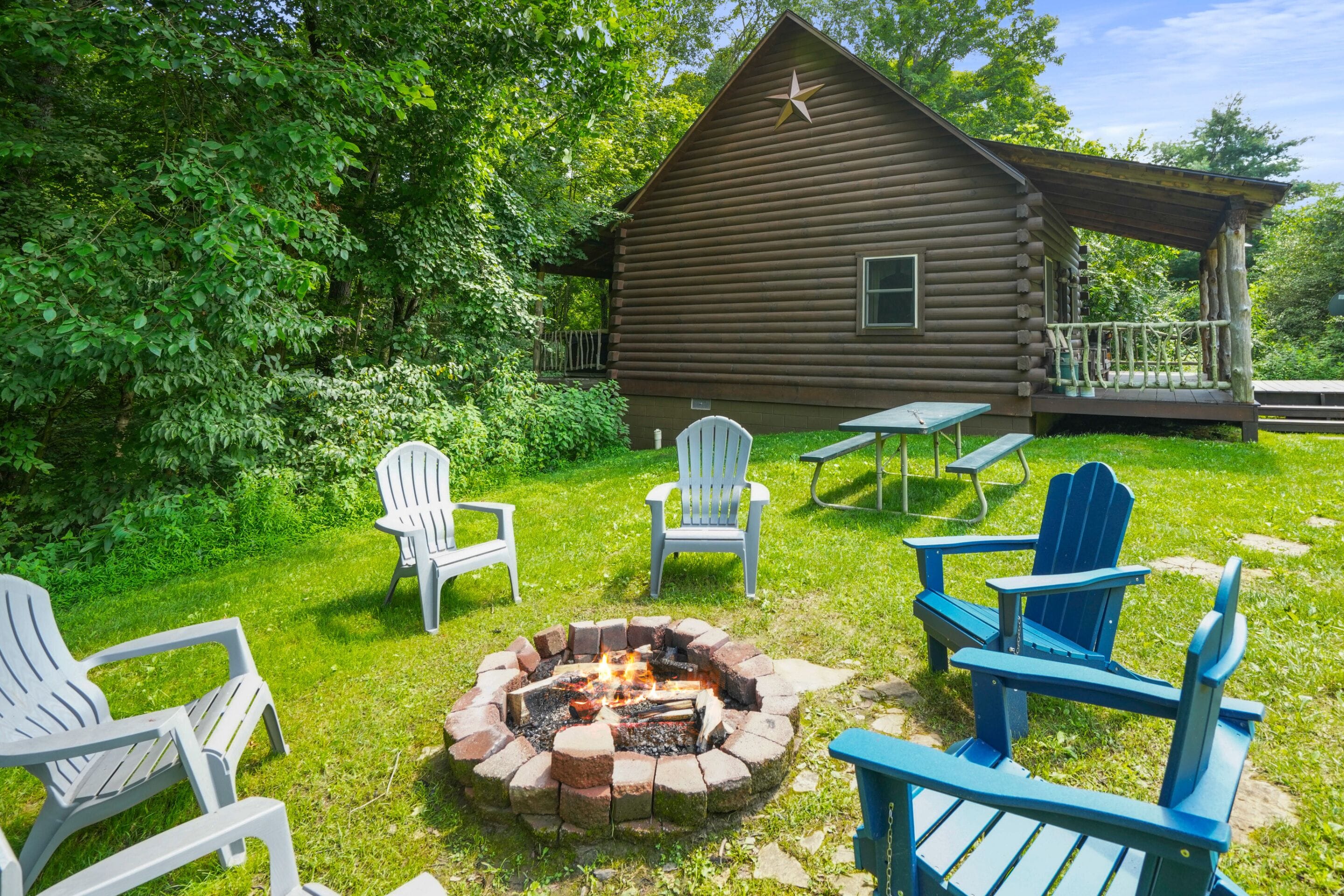 A log cabin with a fire pit and outdoor seating.