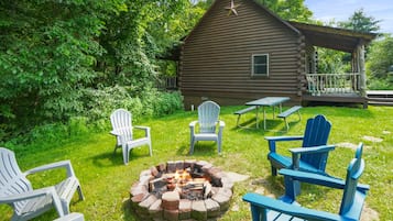 A log cabin with a fire pit and outdoor seating.