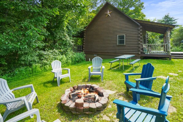 A log cabin with a fire pit and outdoor seating.