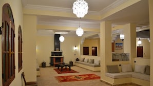 A living room with a fireplace, sofas, and a coffee table. - KASBAH NTIFA (Ait Taguella)