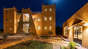 A large, well-lit building with multiple windows and a central entrance. - KASBAH NTIFA (Ait Taguella)