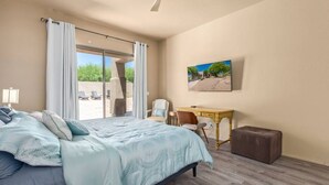 A bedroom with a large bed, a desk, and a chair. There is a window with curtains and a view of the outside. - Troon/Gated/Pool/Firepit/Sleep 6 (Scottsdale)