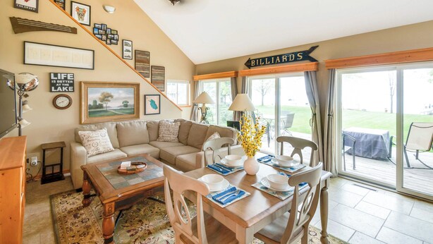 A cozy living room with a sofa, dining table, and a billiards sign. - Waterfront Johnson Lake Getaway w/ Fire Pit! (Johnson Lake)