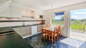 Una cocina moderna con comedor, un ventanal y vistas al exterior.