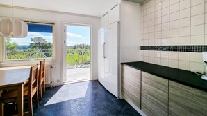 Una cocina moderna con vistas a un paisaje verde a través de un ventanal.