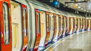 Eine U-Bahn-Station mit mehreren Zugtüren, einem gefliesten Boden und Deckenbeleuchtung.
