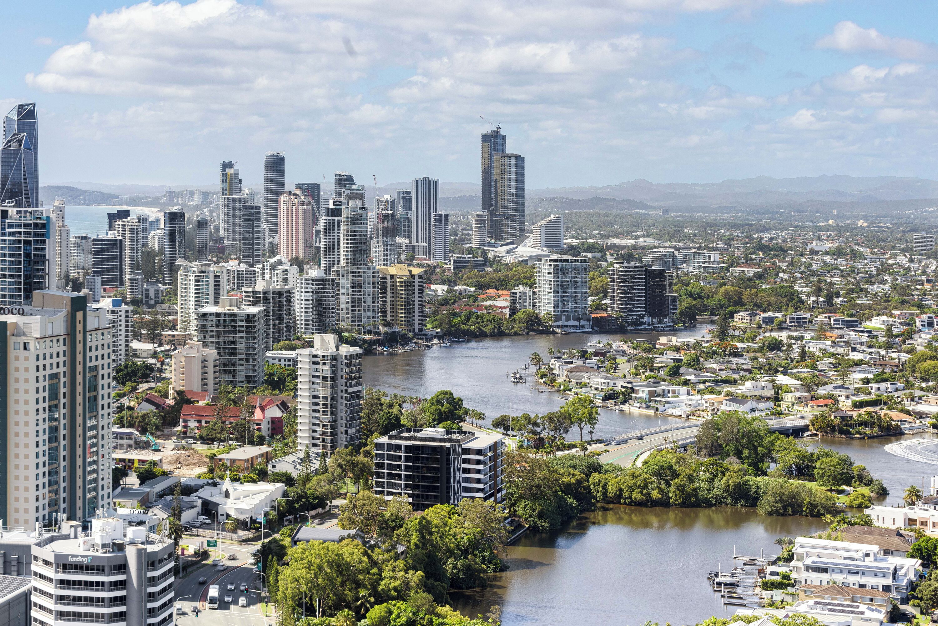 A cityscape with high-rise buildings, a river, and a bridge.