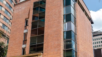 Un edificio moderno con fachada de ladrillo, ventanas amplias y una escalera que lleva a la entrada.